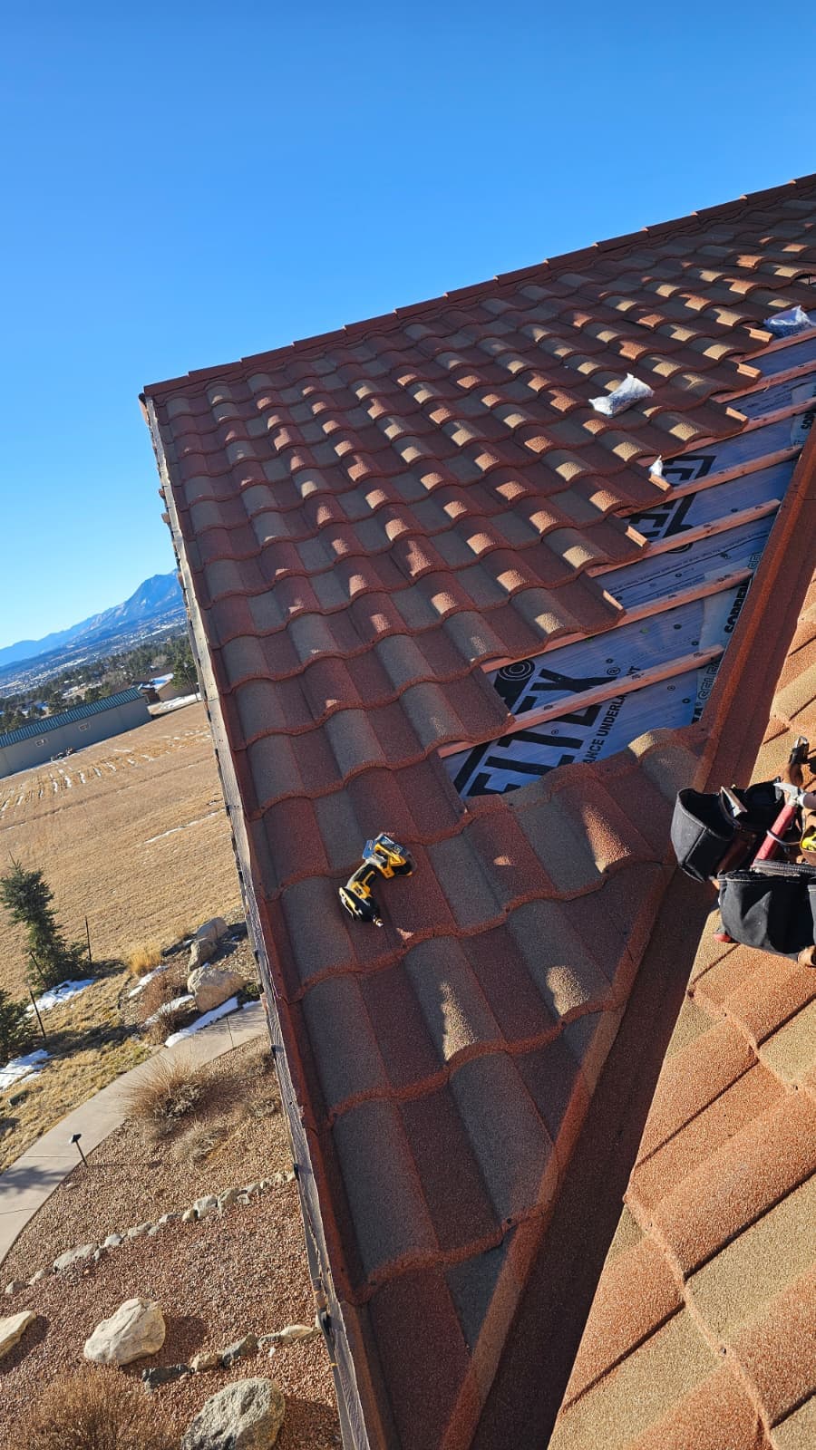 Crew tearing off an old asphalt shingle roof before replacement