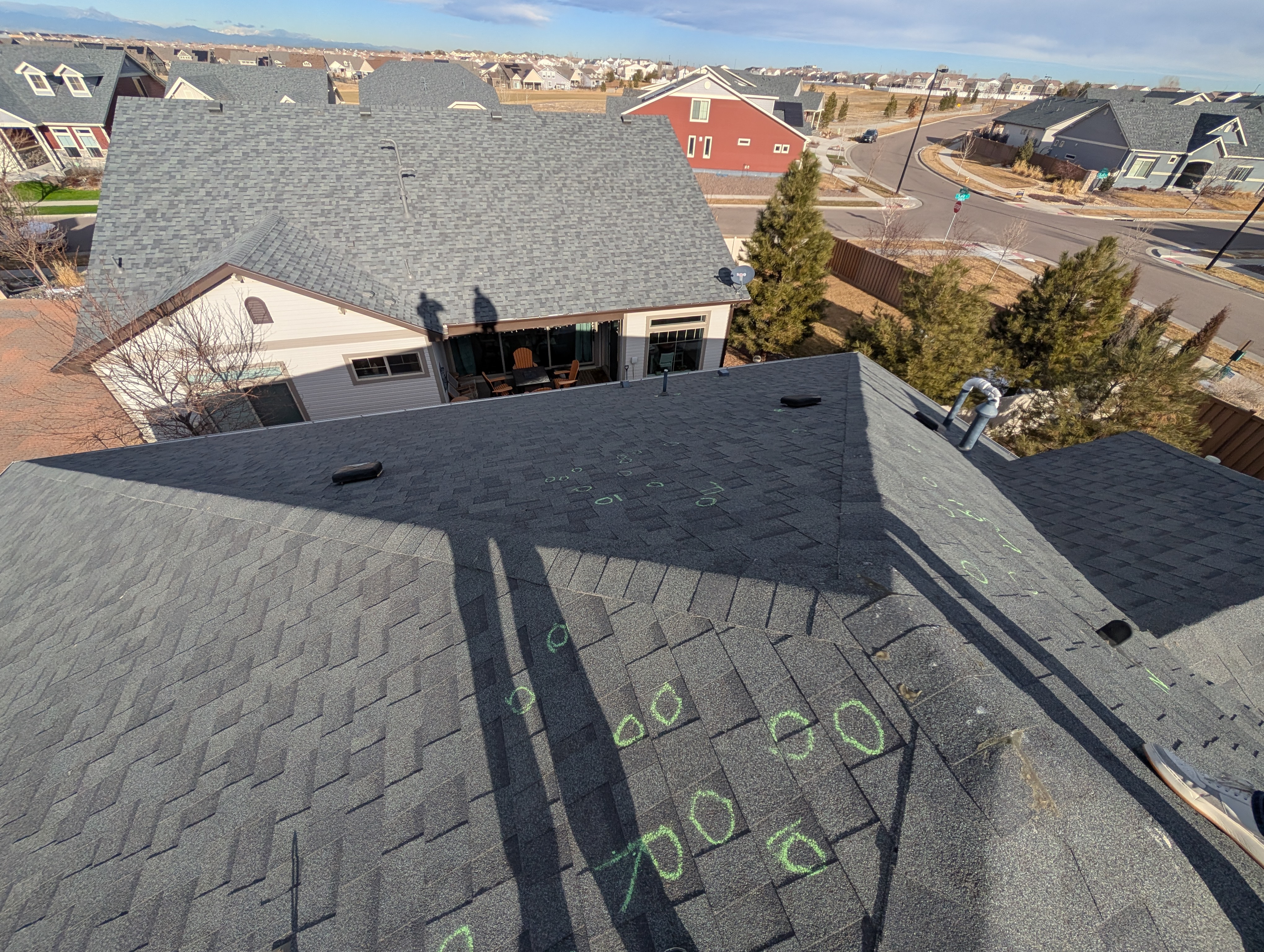 Asphalt shingle roof with chalk inspection markings for hail claim review