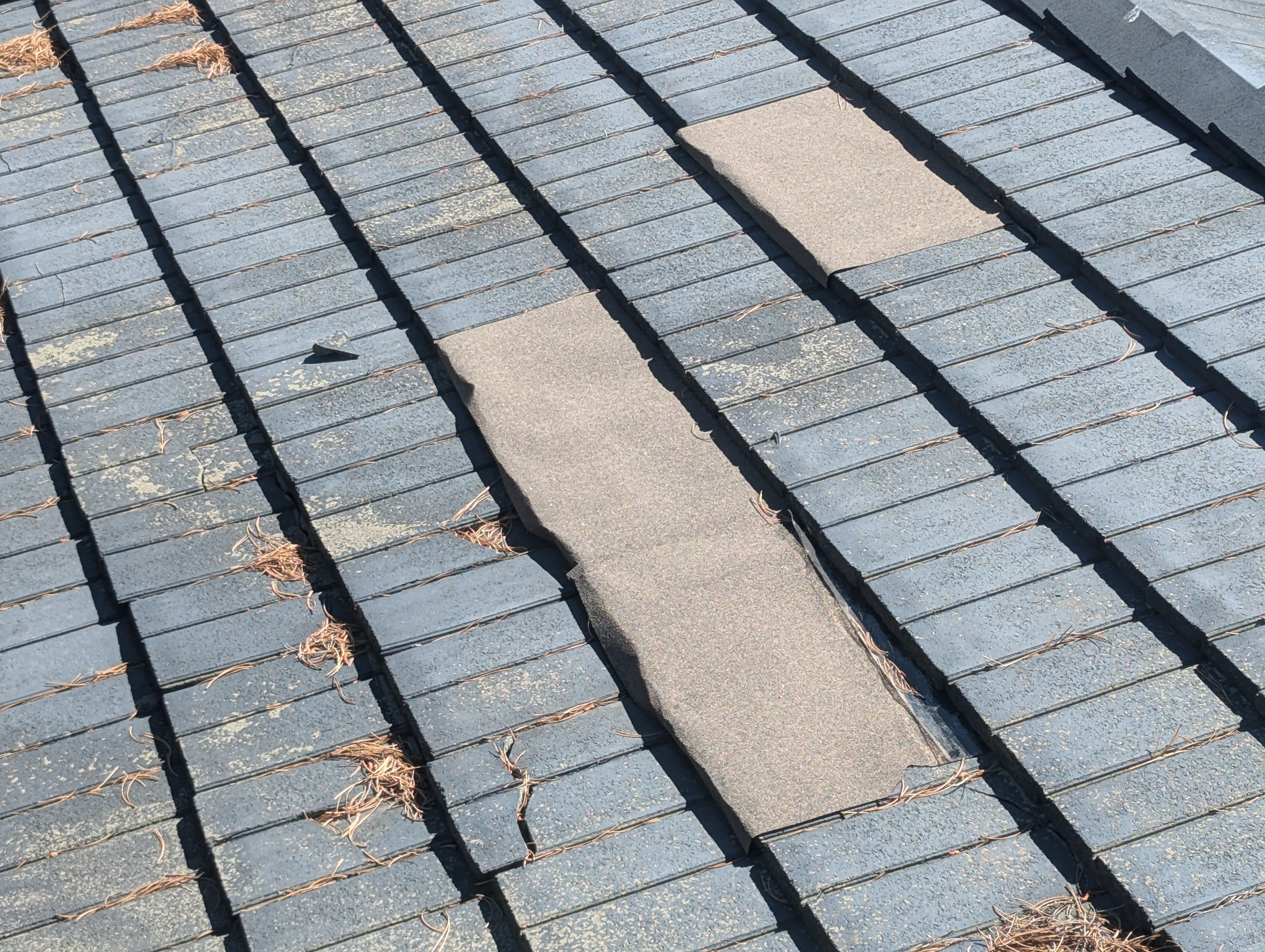 Concrete tile roof with missing tiles after storm damage